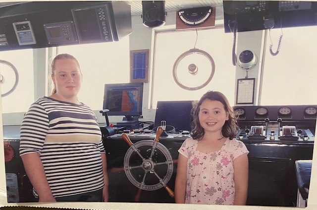 2 Girls on a homeschool Field Trip standing in the cabin of a boat in front of the wheels