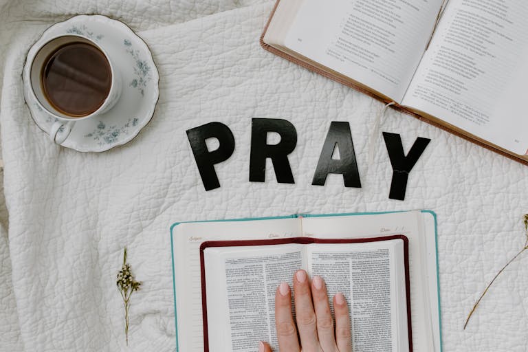 Flat lay of morning prayer routine for homeschool mom including Bible, coffee, and 'PRAY' letters. Blog post titles Homeschool Curriculum: Why the bible is the most important book.